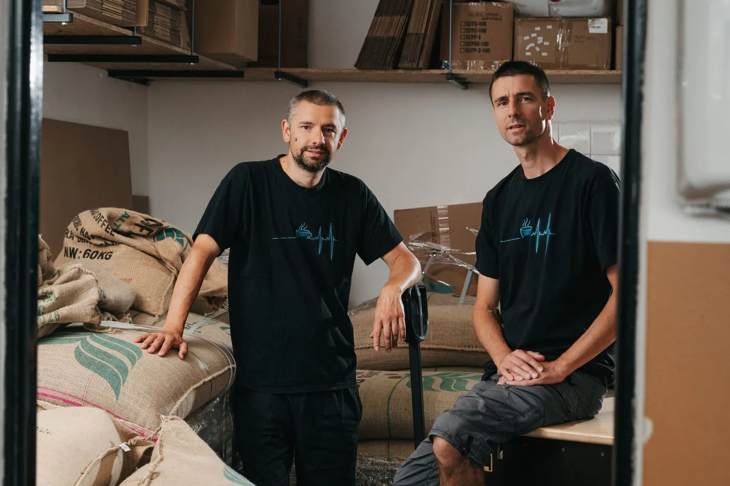 Petr a Jiří Leštinové ve skladu pražírny mezi pytli se zelenou kávou